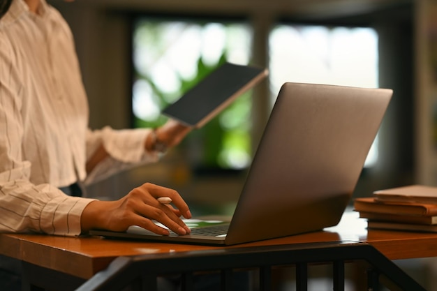 Young woman working online from home surfing internet with laptop computer