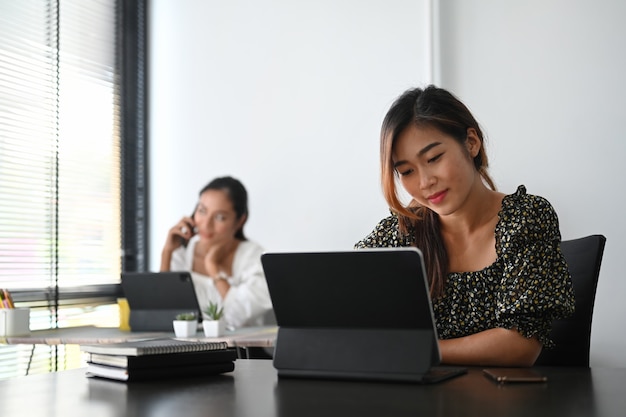 Young woman working on tablet at modern office