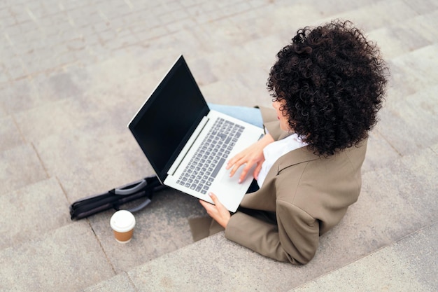 Young woman working with laptop computer outdoors