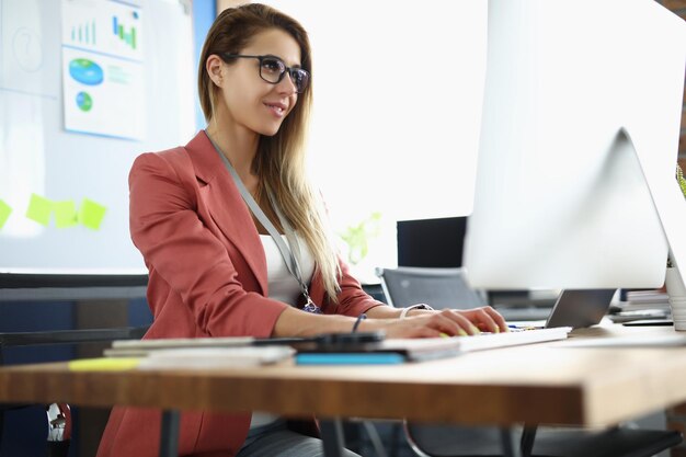 Young woman works at the computer in the office