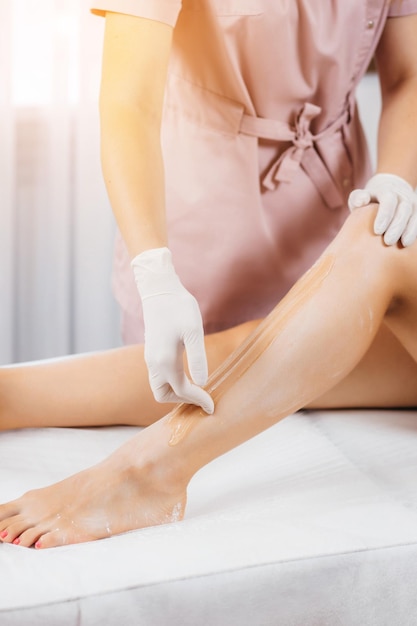 Young womans legs wax with shugaring