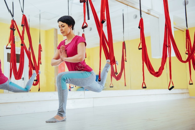 Young women doing yoga exercise or aerial yoga antigravity in the studio.