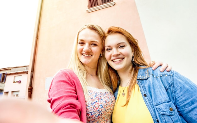 Young women girlfriends taking selfie at old town