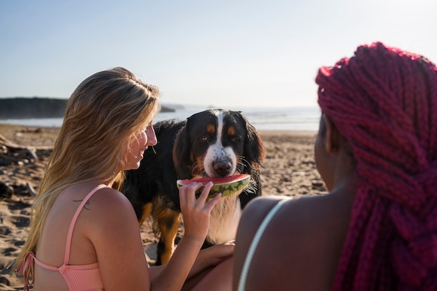 Photo young women having fun with  dog at the beach