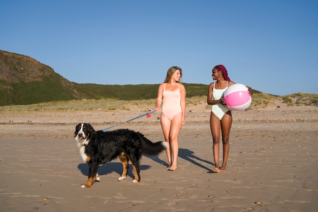 Photo young women having fun with  dog at the beach