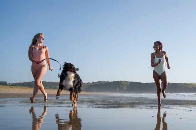 Photo young women having fun with  dog at the beach