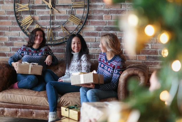 Young women surprise each other with christmas gifts