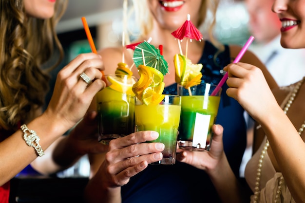 Young women with cocktails in bar or club