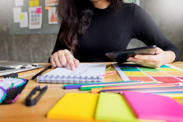 young women working as fashion designer drawing sketches for clothes 