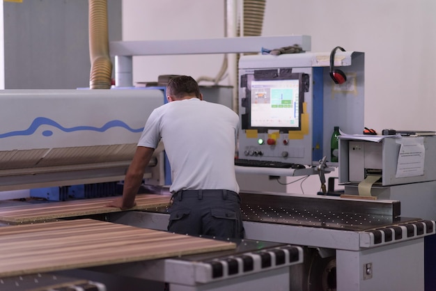 Young worker works in a factory for the production of wooden furniture