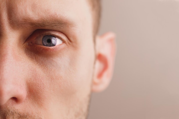 Young worried man with stern look closeup portrait half face