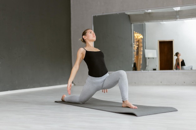 Young yogi attractive woman practicing yoga hatha Doing indoor yoga on the mat Healthy lifestyle