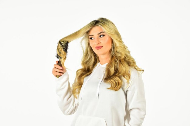 Your Beautiful Hair. Perfect makeup and curls. beauty face. Hairdressing salon. Healthy Long Blond Hair. Beautiful woman curling long hair using hairbrush. beauty and fashion. Hairstyle wavy curls.