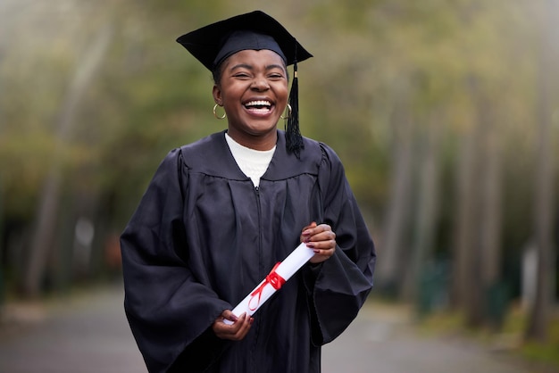 Your girl just got qualified. Portrait of a young woman holding her diploma on graduation day.