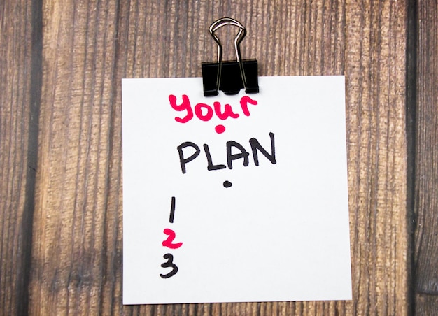 YOUR PLANS text written with a marker on a piece of paper on the table