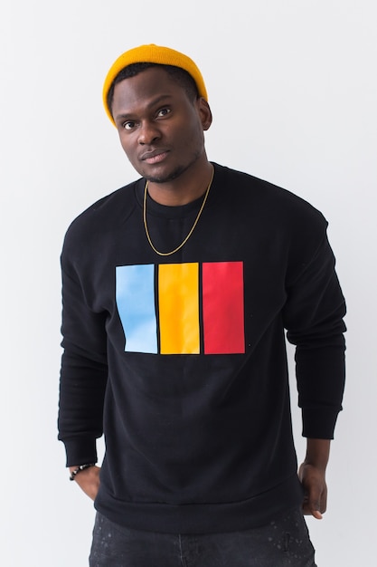 Youth street fashion concept - Portrait of confident sexy black man in stylish sweatshirt on white