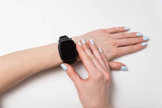 Youth watch on woman's wrist. watch on white surface, black blank display