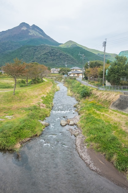 Yufuin village, river, Yufu mountain and blue sky with cloud background, Yufuin, Oita, Kyushu, Japan