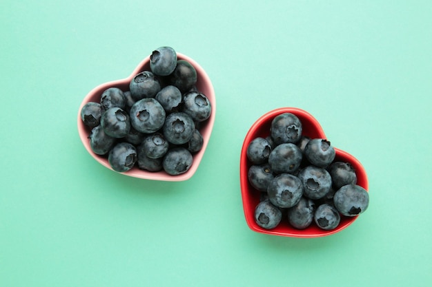 Yummy fresh blueberries in a red and pink shaped heart bowl Top view