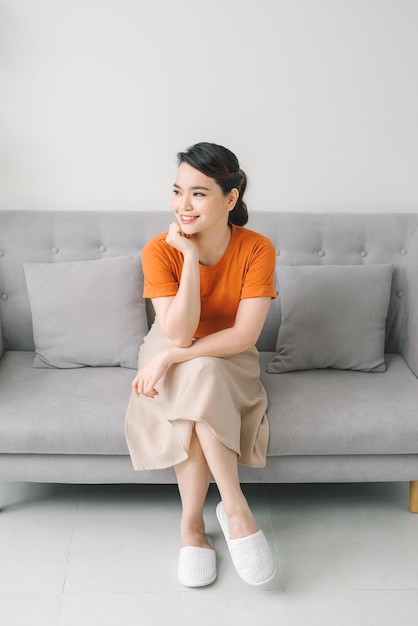 Yuong woman sitting on her white sofa