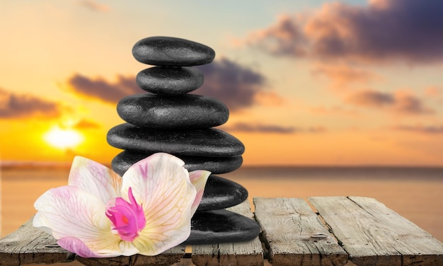 Zen basalt stones and flower on wooden table