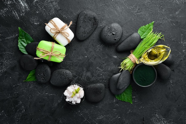 Zen stones and leaves with water drops Spa background with spa accessories on a dark background Top view Free space for your text