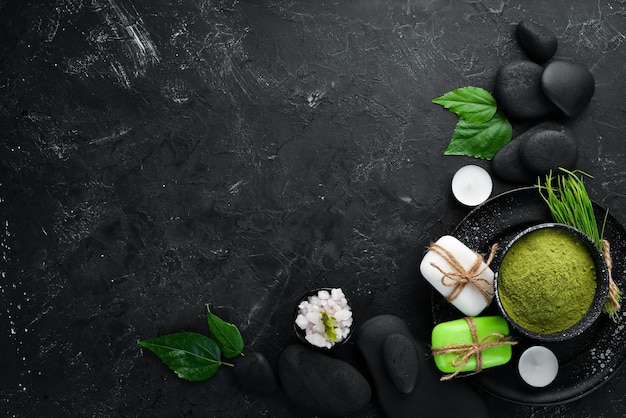 Zen stones and leaves with water drops Spa background with spa accessories on a dark background Top view Free space for your text