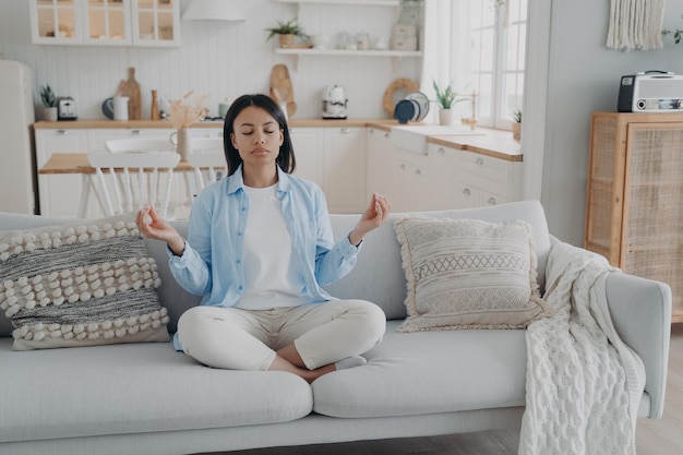 Zen tranquility and breath control Spanish woman is practicing yoga gymnastics in living room