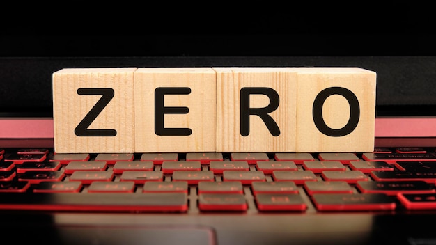 Zero the inscription on wooden cubes on the illuminated laptop keyboard