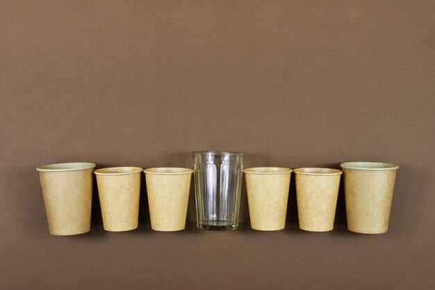 Zero waste concept Disposable paper cups against a glass refillable glass