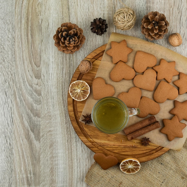 Zero waste concept New Year Cup of tea with cookies on a wooden tray Ginger star anise cones lemon