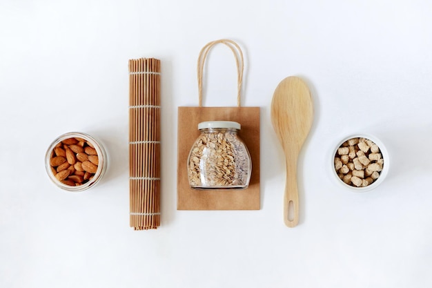 Zero waste concept Top view paper bag bamboo mat glass jar with oatmeal granola almonds