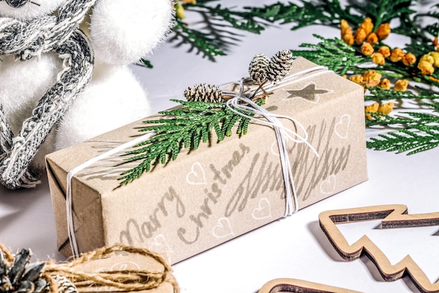 Zero waste and eco friendly christmas concept flat lay with gift, cone and pine branches on white background.