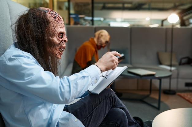 Zombie employees reading books during work break sitting on sofa in lobby of business building. Office open space, coworking