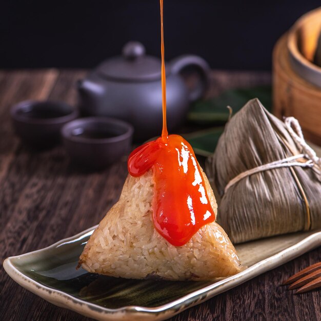 Zongzi Chinese rice dumpling zongzi in a steamer on wooden table black retro background for Dragon Boat Festival celebration close up copy space