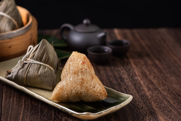 Zongzi. Rice dumpling for Chinese traditional Dragon Boat Festival (Duanwu Festival) on dark wooden table background.