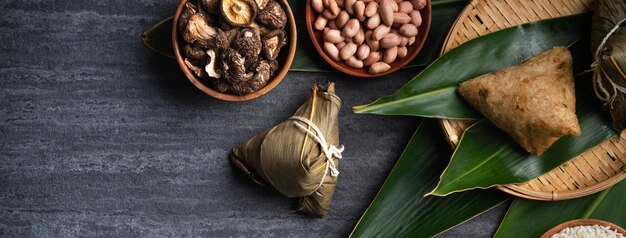 Zongzi. Rice dumpling top view design concept for Chinese traditional Dragon Boat Festival (Duanwu Festival) over dark black slate background.