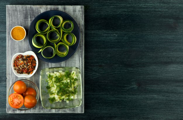 Zucchini in the background. Fried young sliced courgettes in a pan on a dark background. The view from the top. Copy space