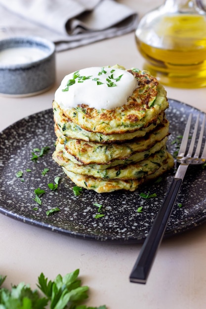 Zucchini fritters or pancakes with sour cream and herbs Healthy eating Vegetarian food