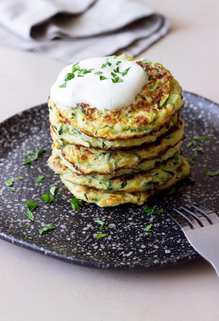 Zucchini fritters or pancakes with sour cream and herbs Healthy eating Vegetarian food