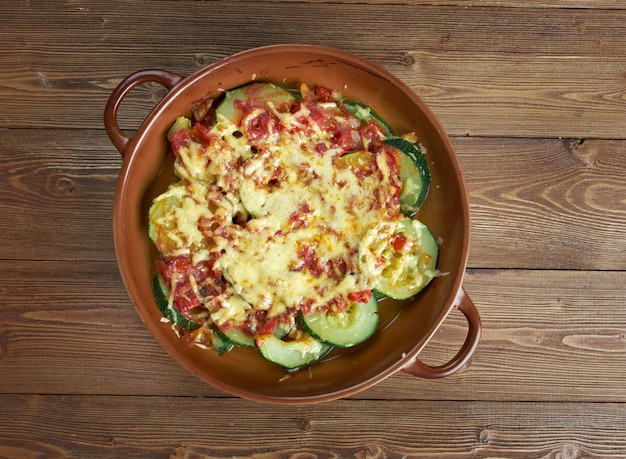 Zucchini with cheese and tomatoes on wooden table. Turkish cuisine