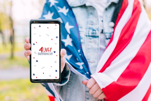 4th july independence day of united states of america. woman holding a smartphone