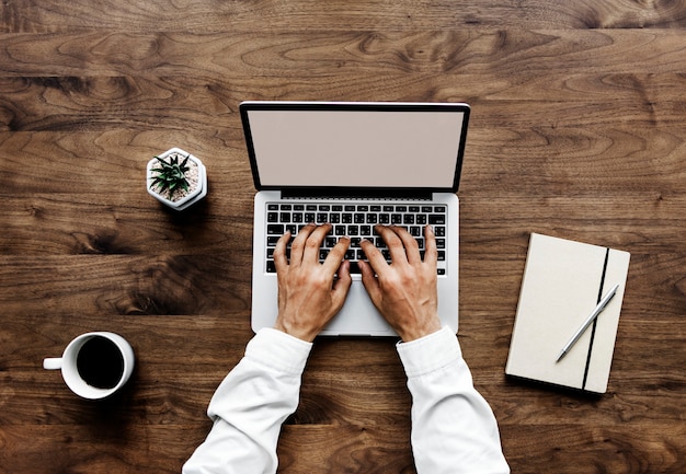 PSD aerial view of a man using computer laptop on wooden table