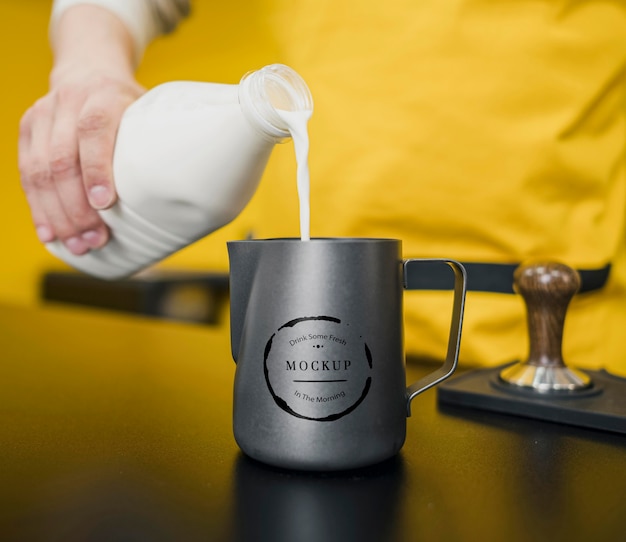 Barista pouring milk in jug mock-up