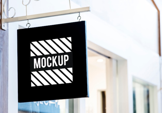 PSD black sign mockup outside a shop