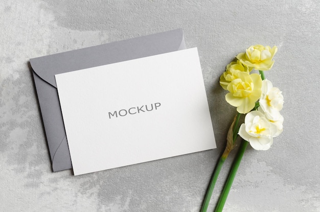 Blank greeting card mockup with envelope and daffodils flowers