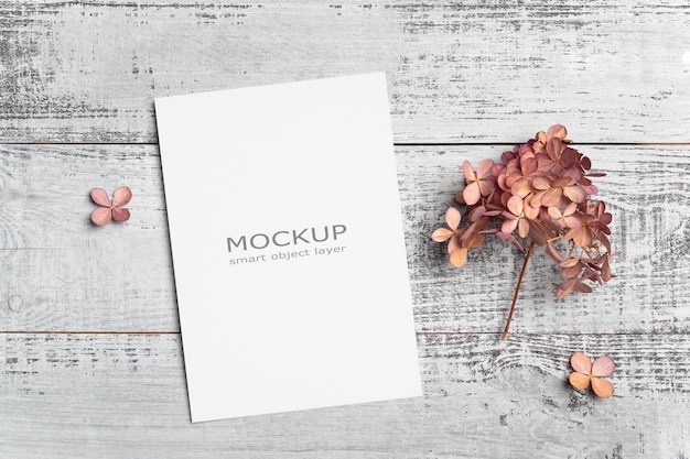 Blank greeting or invitation card mockup on wooden background