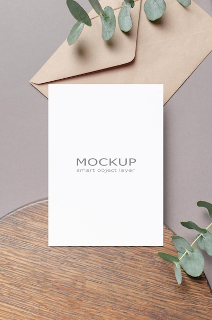 Blank invitation card mockup with envelope and fresh eucalyptus twigs