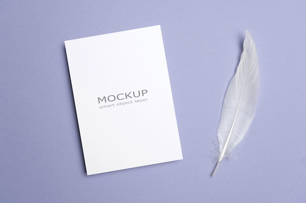 Blank paper invitation or flyer card mockup with white feather decor