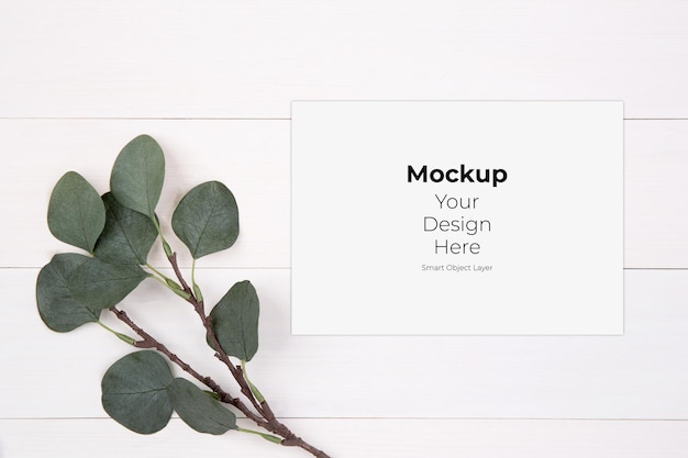 Blank paper sheet with mockup and leaf on wooden table